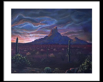 May include: A framed painting of a desert landscape at dusk. The scene features a mountain range under a dramatic sky with shades of blue, purple, and orange. Saguaro cacti and desert vegetation are in the foreground.