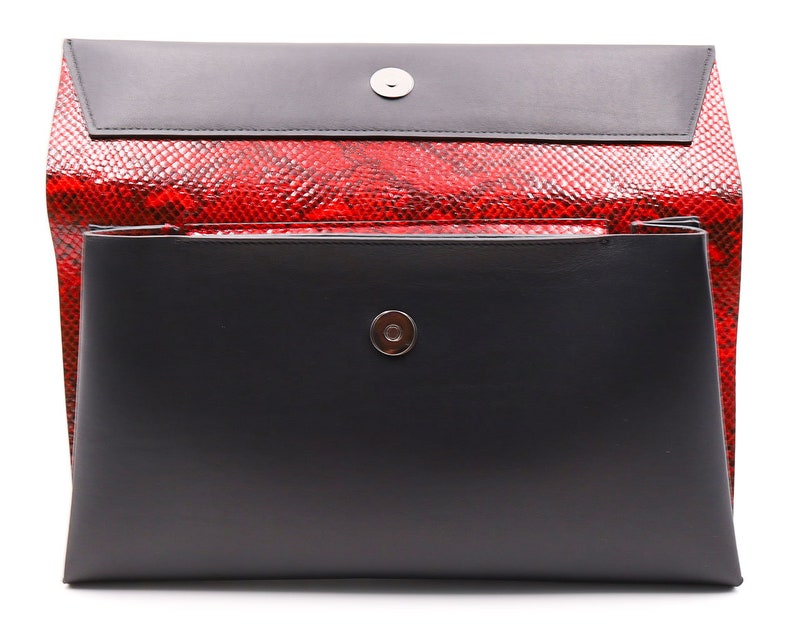 May include: A black and red clutch bag with a magnetic closure. The bag has a red snakeskin pattern and a black flap. The rectangular bag has a silver-coloured magnetic snap.