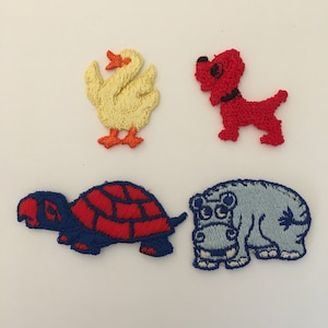 May include: Four embroidered iron-on patches featuring a yellow duck, a red dog, a blue turtle with a red shell, and a blue hippopotamus.