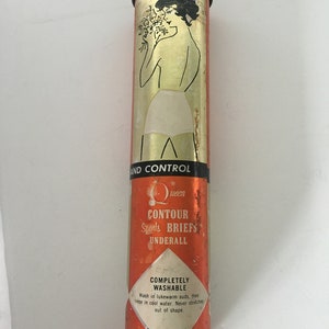 Könnte beinhalten: Vintage zylindrische Dose mit orangefarbenem und goldenem Design. Die Dose zeigt eine Illustration einer Frau und den Text "Queen CONTOUR Sports BRIEFS UNDERALL". Die Dose enthält auch Waschanweisungen.