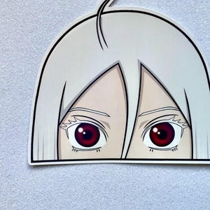 Peut inclure: Un autocollant représentant une personne aux cheveux blancs et aux yeux rouges qui regarde par-dessus une surface. Seuls les yeux sont visibles.