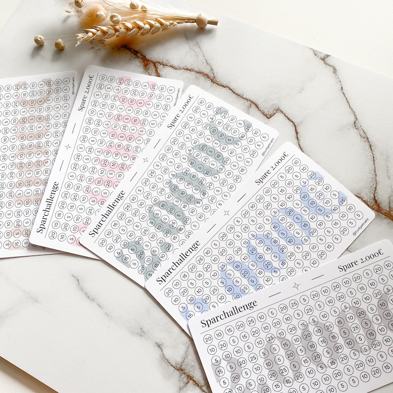 May include: Four printable sheets with a savings challenge tracker. Each sheet has a different color scheme: pink, blue, green, and gray. The sheets are labeled "Sparchallenge" and "Spare 2,000&euro;".