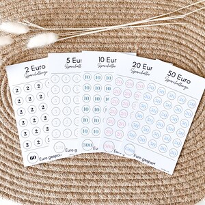Könnte beinhalten: Fünf Blätter weißes Papier mit darauf gedruckten Kreisen. Jedes Blatt hat eine andere Euro-Denomination aufgedruckt: 2, 5, 10, 20 und 50. Die Kreise sind in verschiedenen Farben ausgefüllt: rosa, blau und grau. Der Text "Sparchallenge" ist oben auf jedem Blatt gedruckt.
