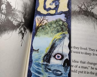 Marcapáginas ilustrado con acuarela basado en un libro de terror sobre un lago de esqueletos maldito que me puso la piel de gallina
