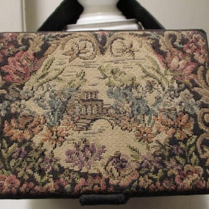 May include: A vintage tapestry style clutch purse with a floral design in shades of brown, pink, green, and blue.
