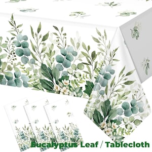 May include: White tablecloth and matching napkins featuring a eucalyptus leaf design. The pattern includes green and blue-green leaves, small white flowers, and stems. The text "Eucalyptus Leaf / Tablecloth" is printed at the bottom.