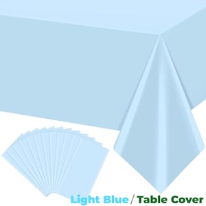 May include: A light blue table cover and matching placemats. The table cover is draped over a table, with a corner folded to show the fabric. A stack of light blue placemats is in the lower left corner. The text "Light Blue / Table Cover" is at the bottom.