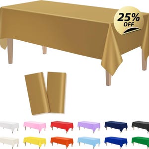 Puede incluir: Un mantel rectangular dorado sobre una mesa de madera, con una pegatina del 25% de descuento. Dos caminos de mesa dorados a juego están delante de la mesa. Se muestran manteles adicionales en varios colores debajo.