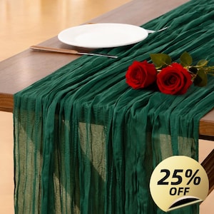 May include: A dark green, pleated table runner draped across a wooden table. A white plate and a knife are on the table. Two red roses rest on the runner. A gold circle with the text "25% OFF" is in the lower right corner.
