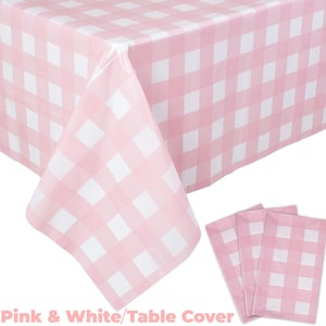 Può includere: Tovaglia a quadri rosa e bianca e tovaglioli coordinati. La tovaglia è drappeggiata su un tavolo, mostrando il motivo. I tovaglioli sono impilati, con lo stesso motivo a quadri rosa e bianchi.