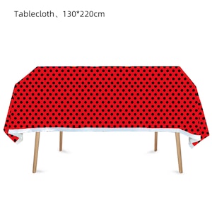 May include: Red tablecloth with black polka dots. Tablecloth measures 130 by 220 centimeters.