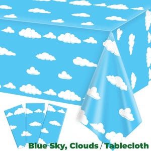 Könnte beinhalten: Eine blaue Tischdecke mit einem Muster aus weißen Wolken. Die Tischdecke ist rechteckig und wird von drei passenden rechteckigen Tischsets mit dem gleichen Wolkenmuster begleitet. Der Text "Blue Sky, Clouds / Tablecloth" ist unten aufgedruckt.