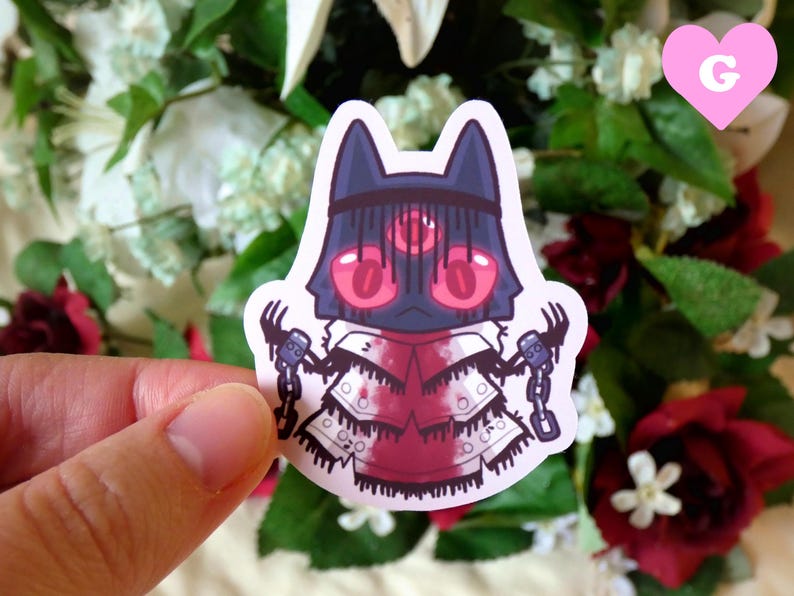 May include: A sticker featuring a cartoon character with a black and red mask, a white robe, and chains. The character has three red eyes and is holding a chain in each hand.