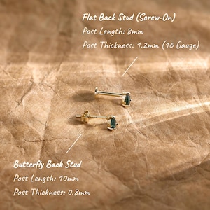 May include: Two gold-tone stud earrings with dark green pear-shaped stones. One is a flat back screw-on stud with an 8mm post length and 1.2mm thickness. The other is a butterfly back stud with a 10mm post length and 0.8mm thickness.
