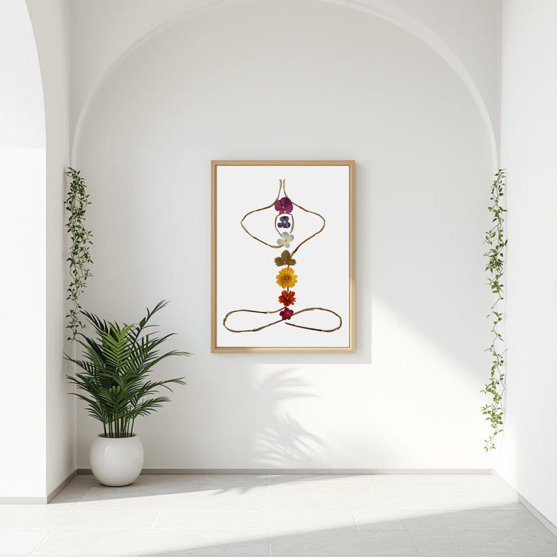 May include: A framed wall art print featuring a human figure in a seated yoga pose, constructed from thin brown twigs and seven colorful pressed flowers arranged vertically along the spine area in shades of purple, blue, white, green, yellow, orange, and red.
