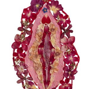 K&ouml;nnte beinhalten: Ein dekoratives Wandkunstobjekt in Vulvaform, bestehend aus einer Collage gepresster Trockenblumen in Dunkelrot, Magenta, Rosa und Violett, mit einer zentralen vertikalen Anordnung aus hellrosa Bl&uuml;tenbl&auml;ttern und Blattwerk.
