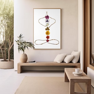 May include: A framed wall art print featuring a stylized human figure in a seated yoga pose. The outline is formed by thin brown twigs, while the central vertical axis is composed of a series of colorful pressed flowers in purple, blue, white, green, yellow, orange, and red.
