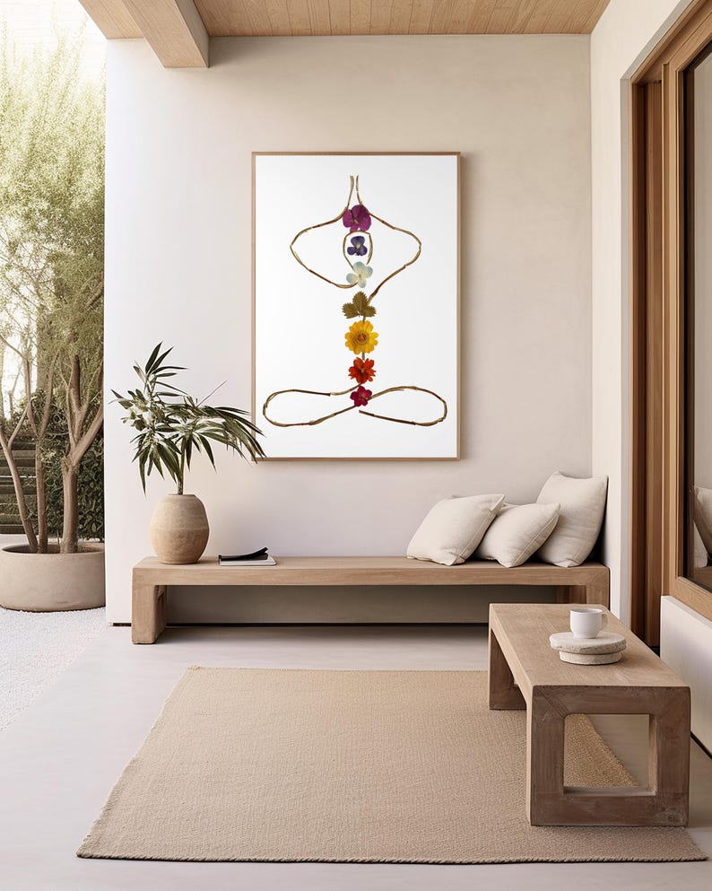May include: A framed wall art print featuring a stylized human figure in a seated yoga pose. The outline is formed by thin brown twigs, while the central vertical axis is composed of a series of colorful pressed flowers in purple, blue, white, green, yellow, orange, and red.