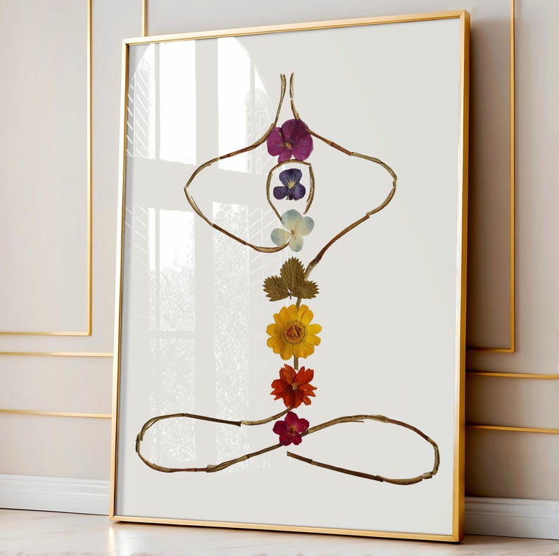 May include: A framed wall art print featuring a yoga pose silhouette constructed from thin brown twigs and pressed flowers. The central vertical axis displays a sequence of purple, blue, white, green, yellow, orange, and red flower blossoms.