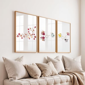May include: A set of three framed wall art prints featuring chemical molecular structures composed of colorful pressed flowers. Each rectangular frame is light wood, displaying intricate floral arrangements that form scientific diagrams.