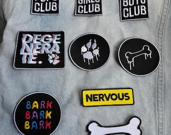 May include: Nine embroidered iron-on patches with various designs. The patches are black, white, yellow, and red. The patches include the text "Good Pups Club", "Good Girls Club", "Good Boys Club", "Degenerate", "Bark Bark Bark", "Nervous", and a paw print, a bone, and a bone with dripping liquid.