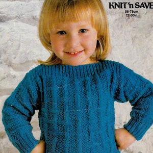 May include: A blue knitted sweater for a child, with a cable knit pattern. The sweater is 22-30 inches in size. The text "KNIT'n SAVE" and "Mr. Buntings Coat" is visible on the image.