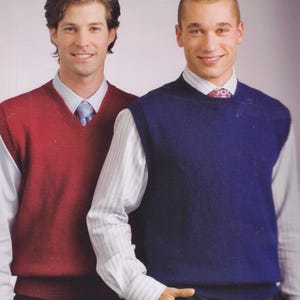 以下が含まれることがあります： 襟付きシャツの上にVネックのセーターベストを着た2人。ベストは濃い赤とネイビーブルー。シャツは白地に控えめな柄。ベストは濃い色のパンツと合わせています。画像には「Mr Buntings Coat」というテキストが入っています。