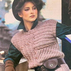 以下が含まれることがあります： ヴィンテージファッションの画像。女性は、ライトブラウンのニットベストを着ています。ベストにはテクスチャード加工のパターンがあります。彼女はまた、黒い帽子、小さなポーチが付いたダークブラウンのベルト、茶色の手袋を着用しています。衣装は、ティール色のスカートで完成しています。