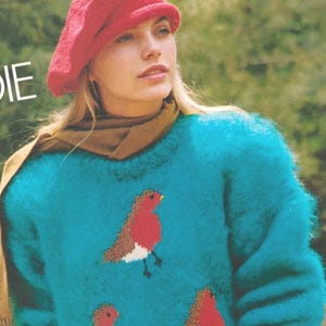 May include: A teal sweater with a crew neck featuring embroidered red robins with brown wings and white bellies. The sweater is paired with a red beret and a brown scarf. The image is a vintage fashion photograph.
