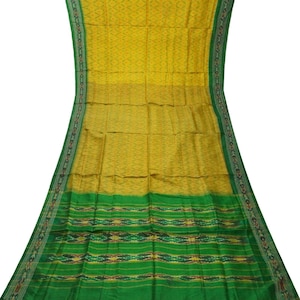 Peut inclure: Un sari en soie jaune et vert avec un motif géométrique. Le sari a une bordure verte avec un motif répétitif.