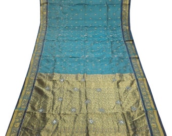 May include: A teal blue and gold embroidered sari with a decorative border. The sari is made of silk and features a traditional Indian design.