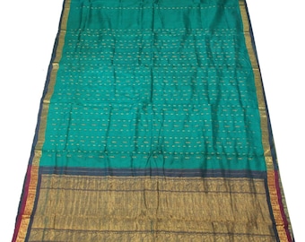 May include: A teal blue saree with a gold and black border. The saree has a subtle pattern of gold thread throughout the fabric.