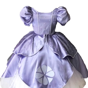 May include: A lavender satin dress with a white tulle underskirt. The dress has a round neckline, puffed sleeves, and a white flower design on the skirt.