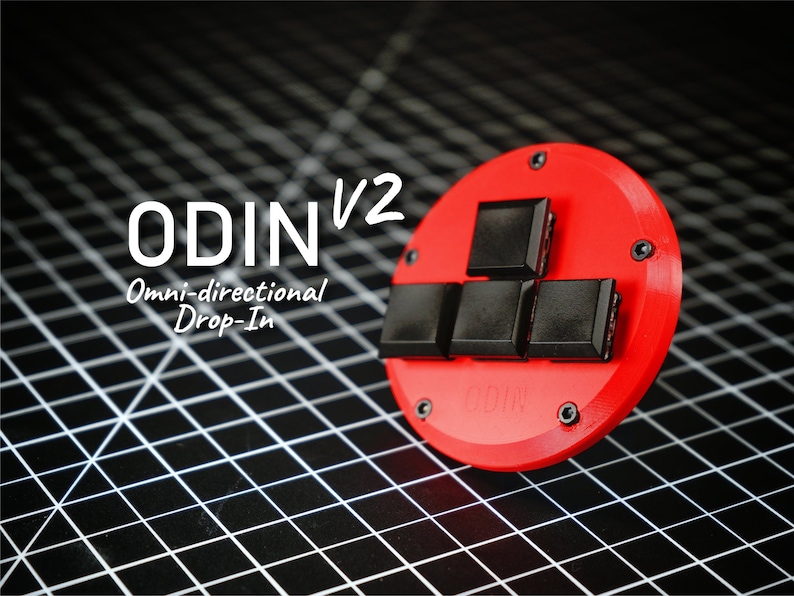Może przedstawiać: Czerwone, okrągłe urządzenie z czterema czarnymi kwadratowymi przyciskami i tekstem "ODIN V2 Omni-directional Drop-In". Urządzenie jest zabezpieczone czarnymi śrubami i leży na czarno-białej siatce.