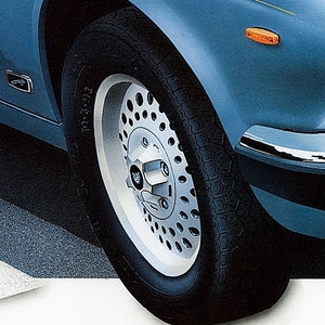 May include: Close-up of a silver and black car wheel with a tire that says "205/70 ZR 15".