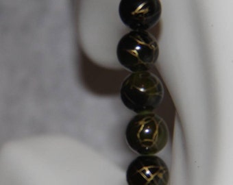 Long dark green earrings with gold swirls