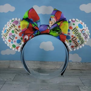 May include: A pair of white and colorful Mickey Mouse ears with a bow. The left ear has the text "Today is A" and the right ear has the text "Core Memory Day".