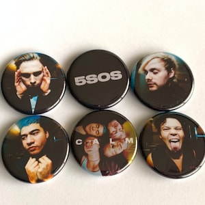 Può includere: Sei bottoni rotondi neri e bianchi con immagini di una band. I bottoni mostrano il viso di un membro della band, il nome della band "5SOS" e una foto di gruppo dei membri della band.