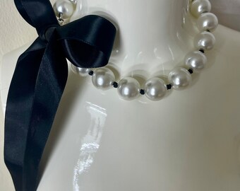 Necklace made of large white pearls (imitation) with a silk ribbon bow