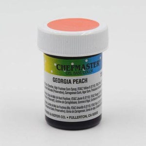 Könnte beinhalten: Ein kleines, rundes Glas mit Georgia Peach Gel-Lebensmittelfarbe. Das Glas ist mit "Chefmaster Gel Base Color" beschriftet und hat einen roten Deckel.