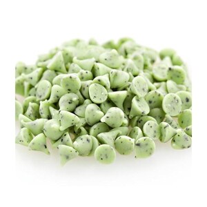 May include: A pile of green and white chocolate chips with a speckled appearance. The chips are in the shape of a teardrop.