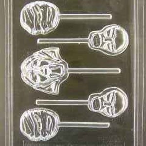 May include: A plastic mold for making chocolate lollipops. The mold has four cavities, two of which are shaped like a tiger's face and two of which are shaped like a swirl.