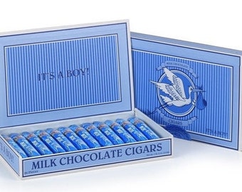 May include: A blue and white box with the words "It's a Boy!" on the lid. The box contains milk chocolate cigars. The box is decorated with a stork carrying a baby.