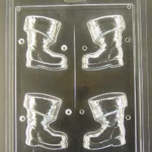 May include: A clear plastic mold for making chocolate candy in the shape of Santa's boots. The mold has four cavities, each shaped like a boot with a folded-over top.