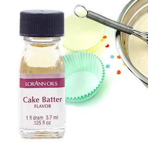 May include: A clear glass bottle with a black cap and a white label. The label says "Lorann Oils Cake Batter Flavor 1 fl dram 3.7 ml .125 fl oz".