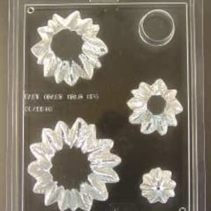 May include: A clear plastic mold for making chocolate sunflowers. The mold has four different sizes of sunflower shapes and one round shape.