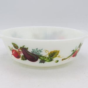 May include: White, round serving bowl with two handles. The bowl features a colorful vegetable design, including a red radish, purple eggplant, and green peas. A vintage kitchenware item.