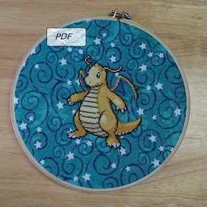 Puede incluir: Un aro de bordado de punto de cruz con un fondo azul que presenta un dragón amarillo con estrellas y remolinos blancos. El texto "PDF" es visible en la esquina superior izquierda de la imagen.