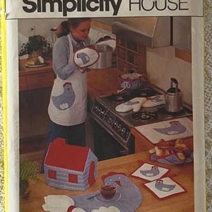 May include: Simplicity House pattern for 10 kitchen items. The image shows a woman in a kitchen with various items, including an apron, oven mitts, pot holders, and a house-shaped item, all featuring a chicken design. The text "10 kitchen items" is visible.