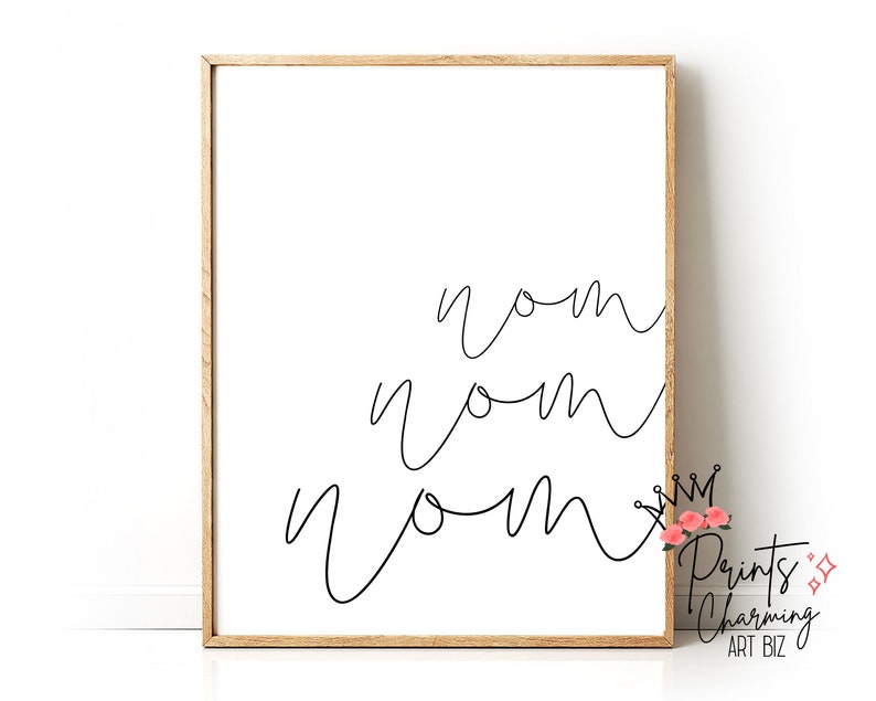 K&ouml;nnte beinhalten: Ein schwarz-wei&szlig;er druckbarer Wandkunstdruck mit dem Wort "nom", das dreimal in einer kursiven Schrift geschrieben ist. Der Druck ist in einem hellbraunen Holzrahmen gerahmt.